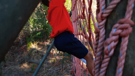 boy climbing down the net during obstacle course