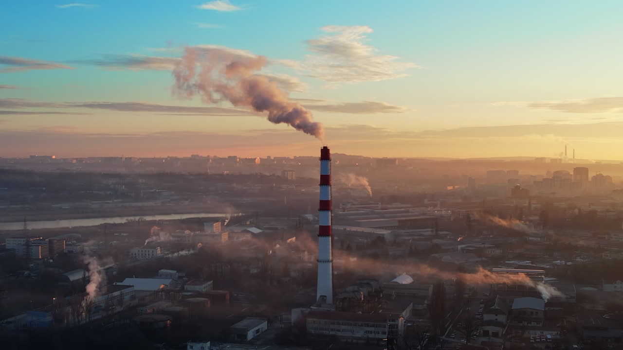 Aerial drone view of thermal power plant in Chisinau at sunrise, Moldova. View of pipe with felling steam, cityscape