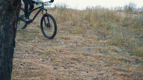 ciclista masculino con mochila y casco montando en bicicleta de montaña cuesta abajo