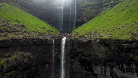 Fossá-Waterfall-in-Faroe-Islands,-aerial-pull-back-tilt-reveal-of-tall-falls