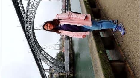 Tourist-smiling-by-Ponte-Dom-Luis-I-in-Porto,-Portugal