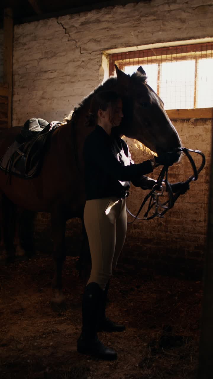Donna che si prende cura di un cavallo nella stalla