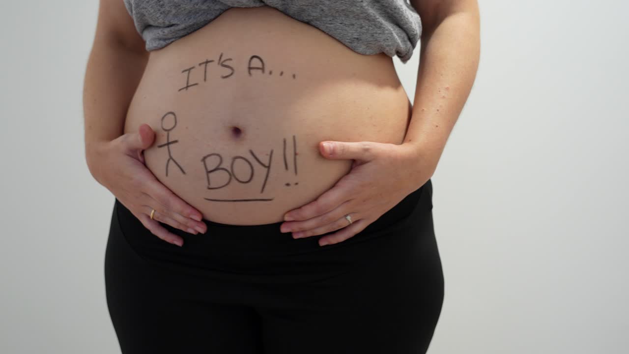 el vientre embarazada se mueve a ambos lados esperando un bebé varón, fondo blanco