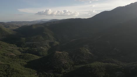 Misty-evening-sunlight-shadows-on-rugged-mountain-forest-terrain