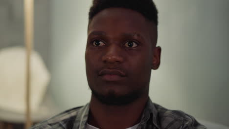 tranquil young african-american man sits in living room