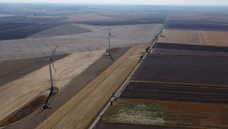 Windkraftanlagen-In-Weitläufigem-Gebiet-Neben-Der-Landstraße,-Drohnenaufnahme