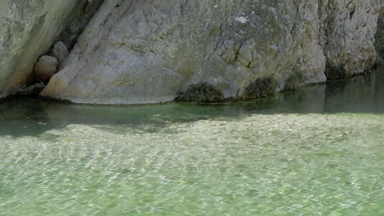 Clear shallow stream at Parrizal de Beceite, rocky cliffside, calm peaceful vibe