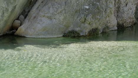 clear shallow stream at parrizal de beceite, rocky cliffside, calm peaceful vibe