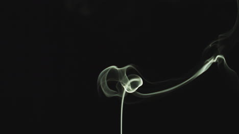 close up of white smoke from candle or incense drifting across frame against black background 2