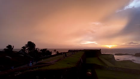 a stunning sunset view over galle fort in sri lanka, highlighting the fort's ancient structures against a vibrant sky. a serene and picturesque scene by the ocean.. pan left