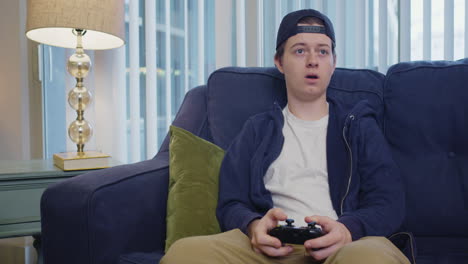 young man flinches while playing video games and is then disappointed