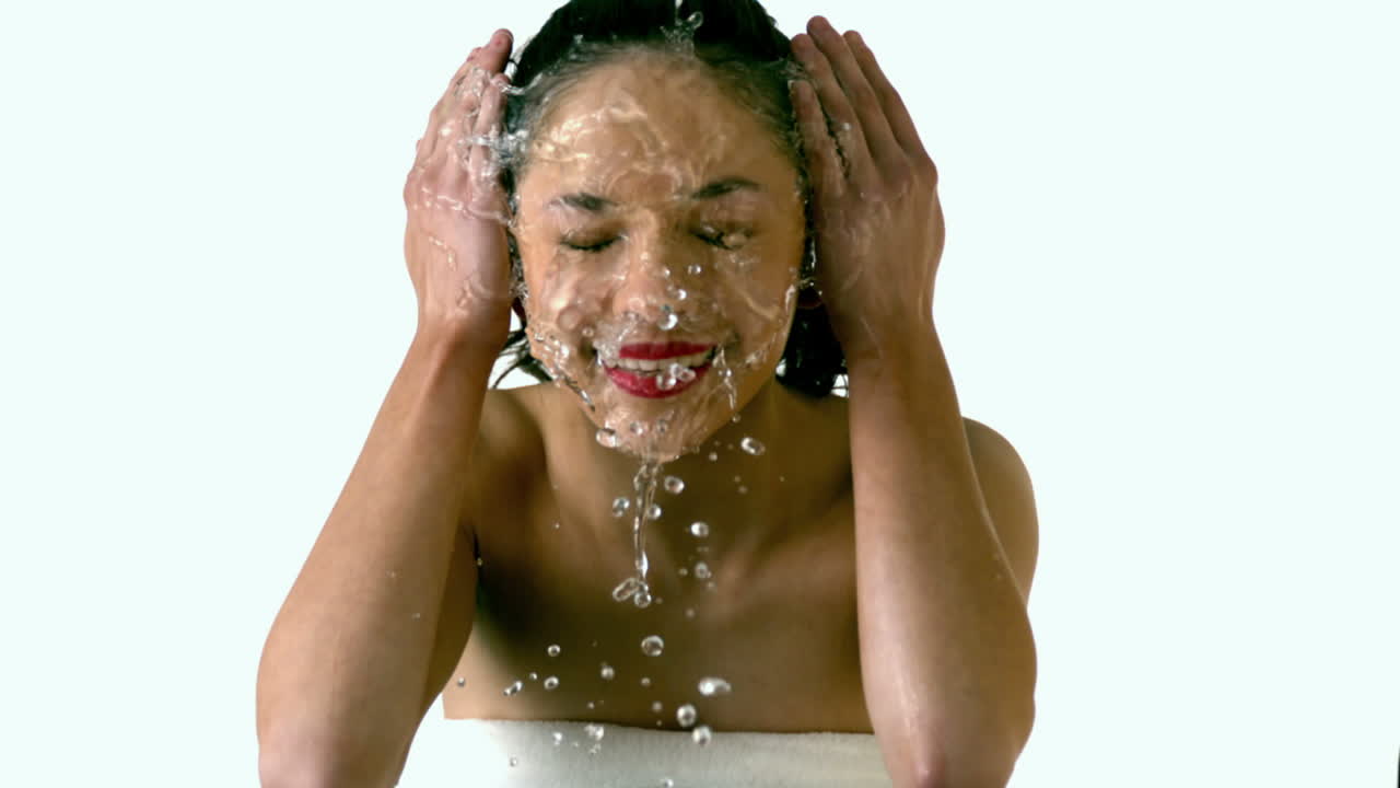 Beautiful brunette splashing her face