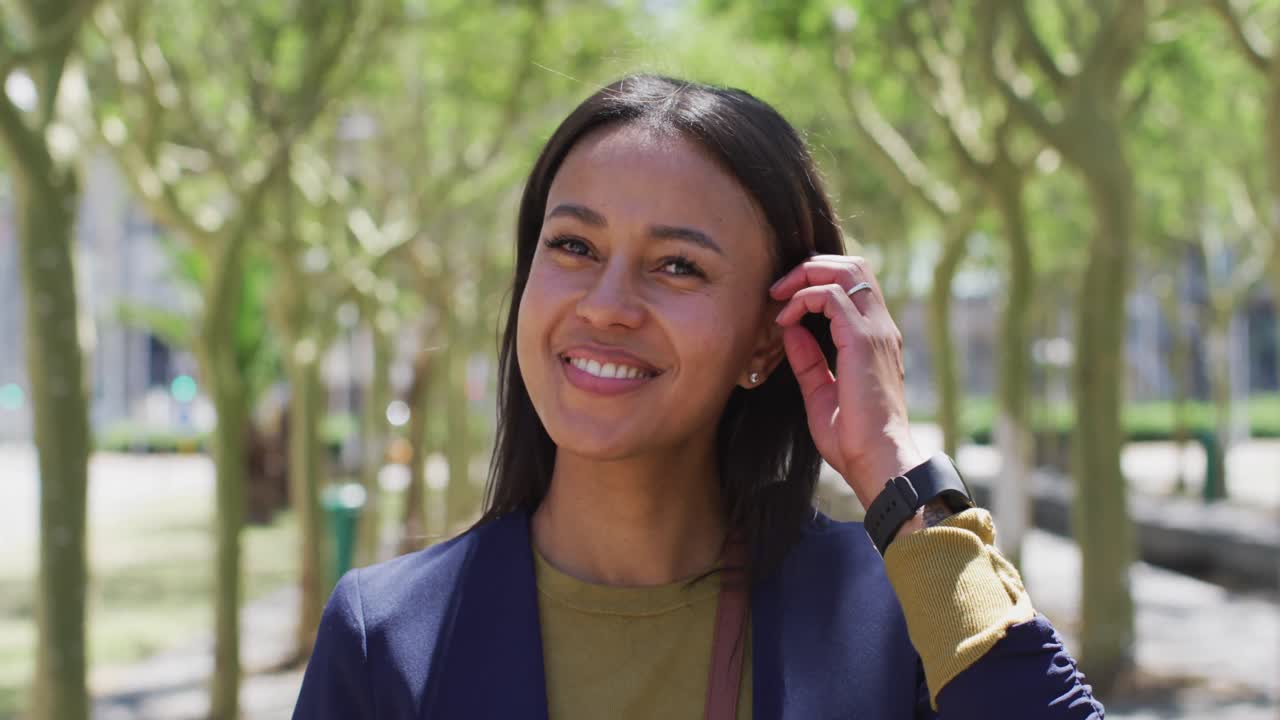 Portrait of african american woman looking at camera and smiling in street