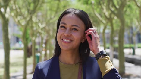 Portrait-of-african-american-woman-looking-at-camera-and-smiling-in-street