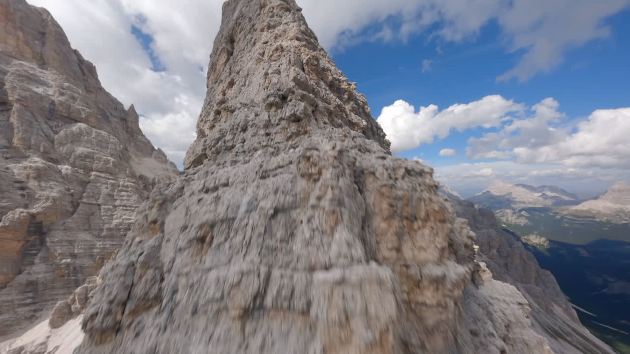 Drone FPV che si alza lungo la cresta affilata della catena montuosa rocciosa delle Dolomiti in Italia.