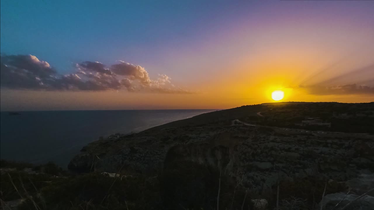 Cores douradas durante o pôr do sol sobre o oceano a partir da Gruta Azul, Malta, timelapse.