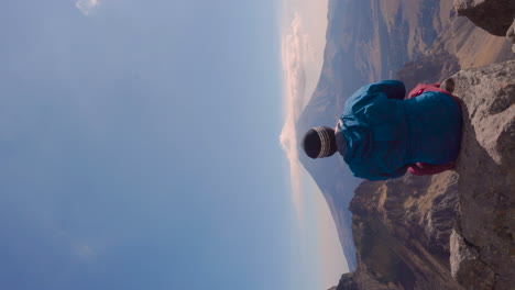 Young-man-sitting-on-the-edge-of-a-cliff