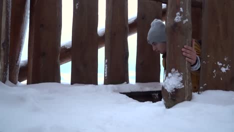 Männchen,-Das-Auf-Der-Aussichtsplattform-Eine-Holztreppe-Hinaufgeht,-Im-Winter-Eingeschneit