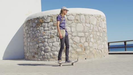 Vídeo-De-Un-Hombre-Caucásico-Con-Rastas-Patinando-En-El-Soleado-Paseo-Marítimo