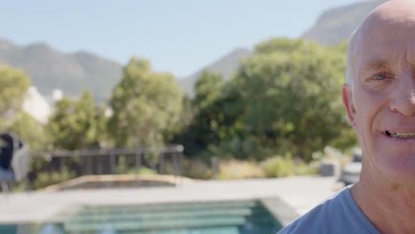 Portrait-of-senior-caucasian-man-smiling-in-sunny-garden,-unaltered,-in-slow-motion,-copy-space