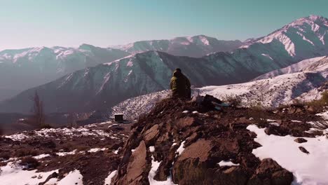 hombre chatea, trabaja, juega online, conectado a celular en montañas nevadas, 5g