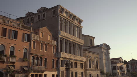 Tiro-Inclinado-Hacia-Arriba-De-La-Fachada-Histórica-Del-Palazzo-Flangini-Iluminada-Por-El-Amanecer-De-La-Mañana,-Venecia,-Italia