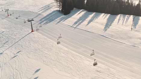 Profil-Drohnenaufnahme-Leerer-Skilifte-über-Frischer-Skipiste