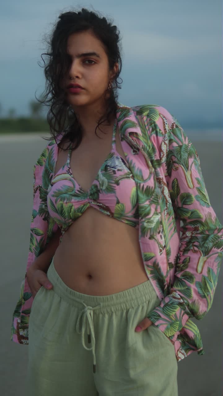 Woman in tropical bikini top enjoying the beach at sunset with relaxed, casual vibe, vertical shot