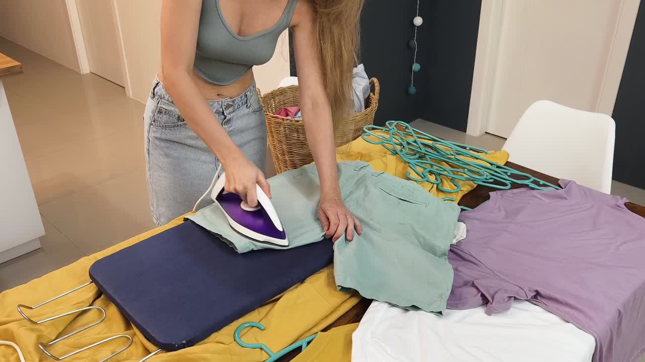 Woman doing laundry and ironing clothes