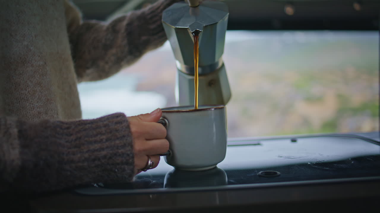 트레일러에서 모카 비에서 커피 컵을 채우는 여자의 손