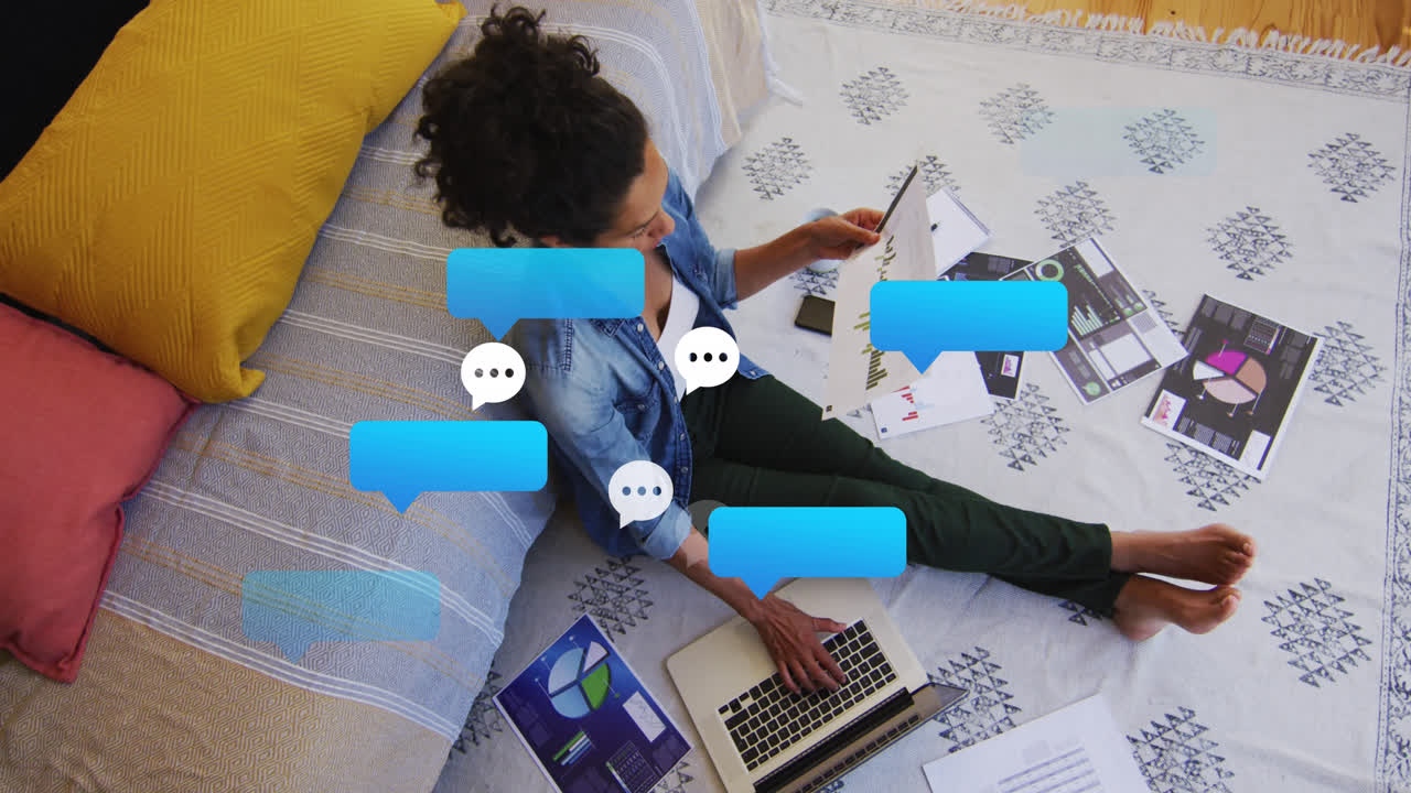 animación de burbujas de redes sociales sobre una mujer biracial trabajando en una computadora portátil en casa