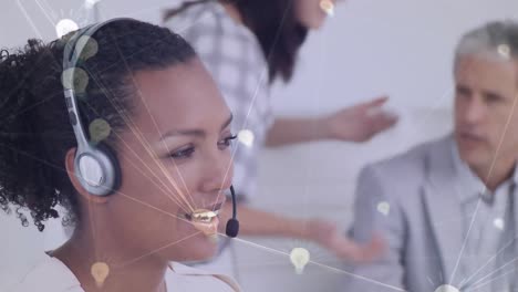 Animation-of-network-of-connection-with-icons-over-business-people-wearing-phone-headsets