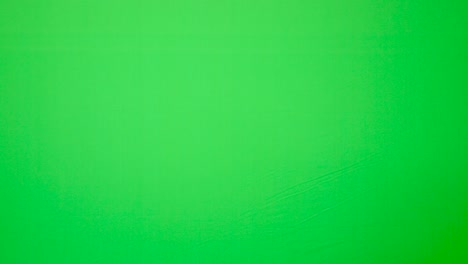 Indian-guy-showing-up-and-saying-hello-to-the-camera-with-waving-hand-with-green-background---green-screen