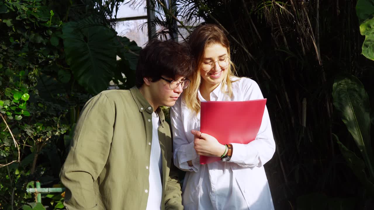 estudiantes estudiando plantas en un invernadero