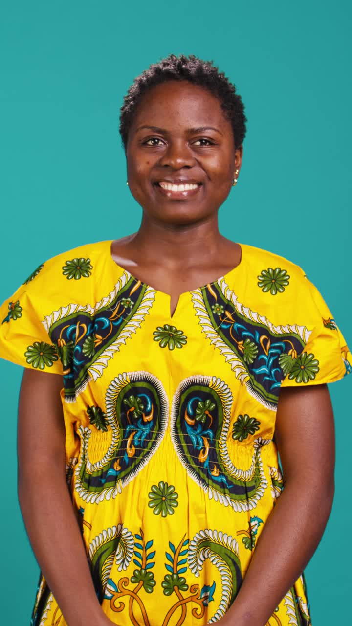 Glad afrikansk kvinna i traditionell klädsel som ler