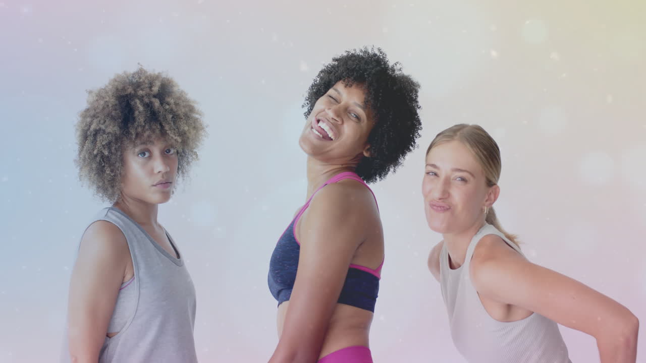 tres mujeres posando en trajes de entrenamiento sobre un fondo de animación brillante