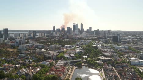 Toma-Aérea-De-Seguimiento-Del-CDB-De-Perth-Con-Humo-De-Fondo-De-Un-Incendio