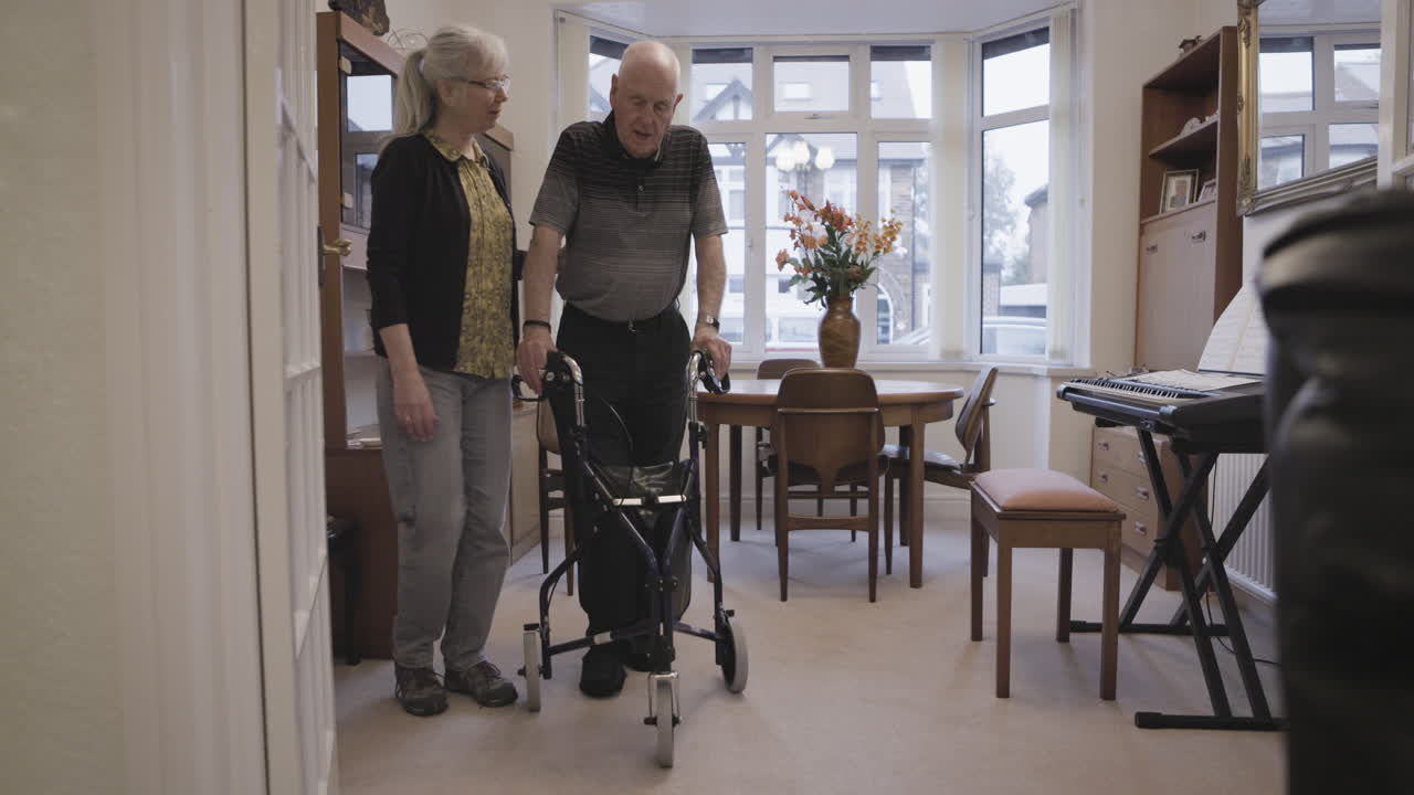 Elderly couple using a walker at home