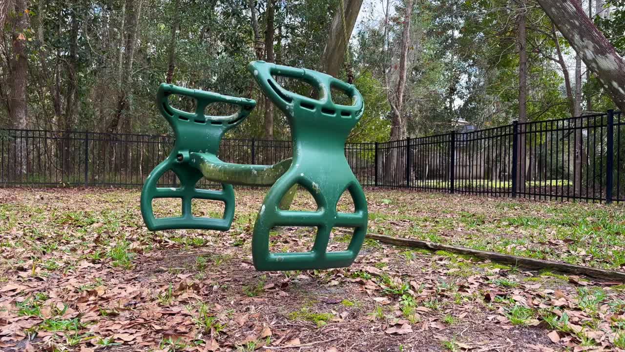 открытый планер качелей, дующий на ветру, без играющих детей, задний двор