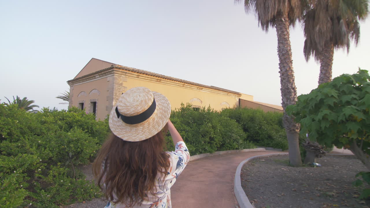 una mujer tomando una foto de un edificio mientras sonríe