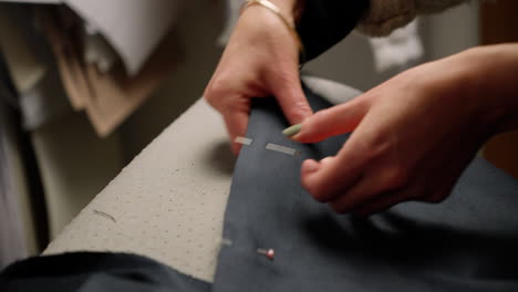 Seamstress-pinning-fabric-material-preparing-to-sew