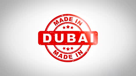 made in dubai signed stamping text wooden stamp animation. red ink on clean white paper surface background with green matte background included.