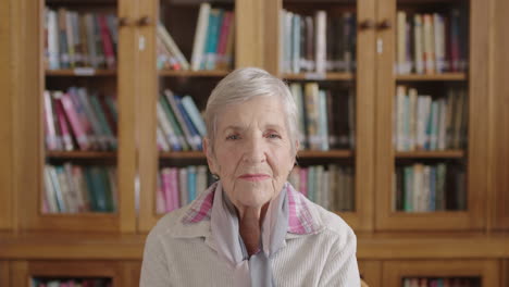 retrato de una anciana mujer caucásica en la biblioteca relajada sintiendo alivio mirando a la cámara