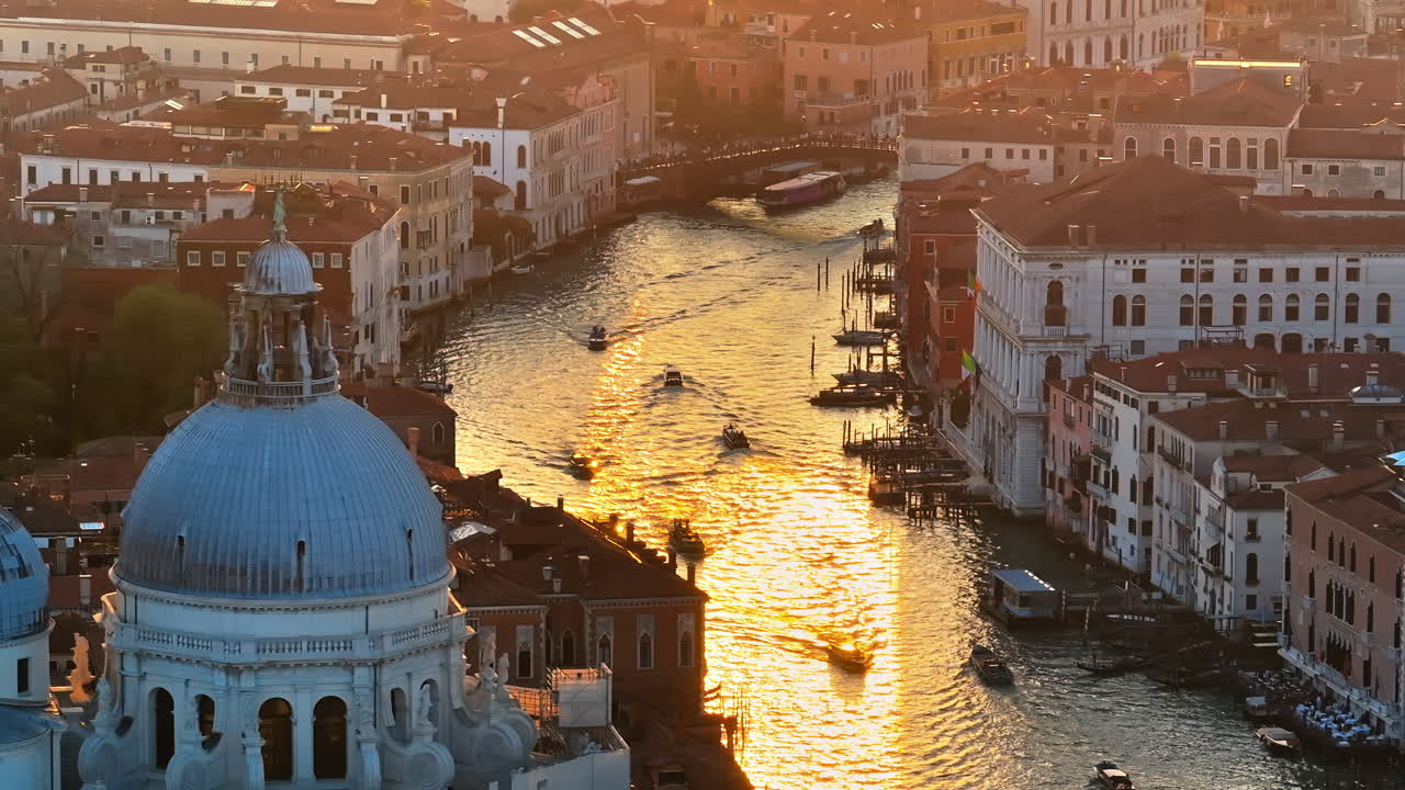 Aerial drone view of boats moving through Venice City, Italy, at sunset