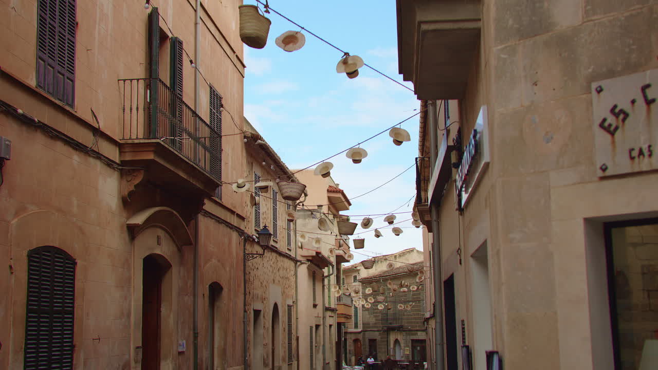 Abandoned alley in Mallorca with a blue sky backdrop. Straw hats sway in the wind on ropes across the street. Shot in slow-motion. Calming video. Perfect for relaxation or as a background.
Clip 011
