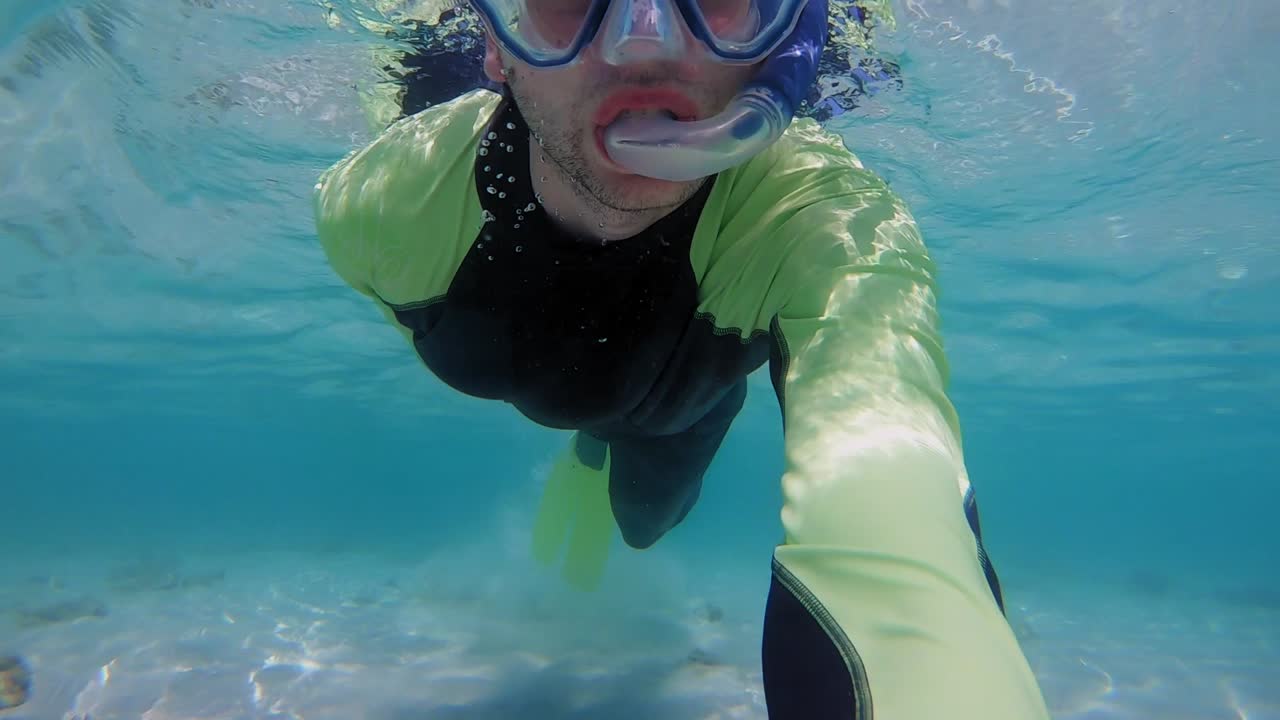 아름다운 맑은 바닷물에서 남성 스노클링의 클로즈업 핸드헬드 샷