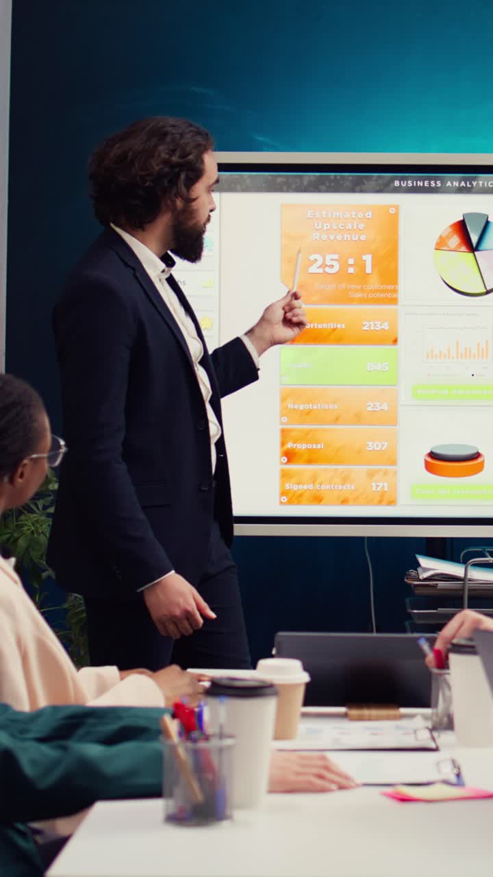 Businessman Presenting Sales Analytics on Interactive Screen in Office Meeting