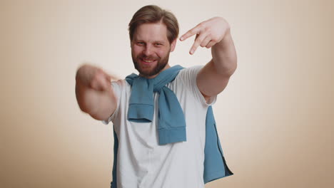 young caucasian man showing victory sign hoping for success and win doing peace gesture smiling