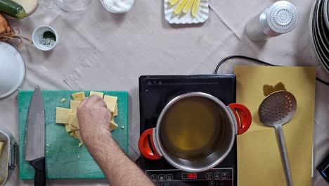 el cocinero comprueba la temperatura del aceite antes de dejar caer en bloques cúbicos de panela en la olla