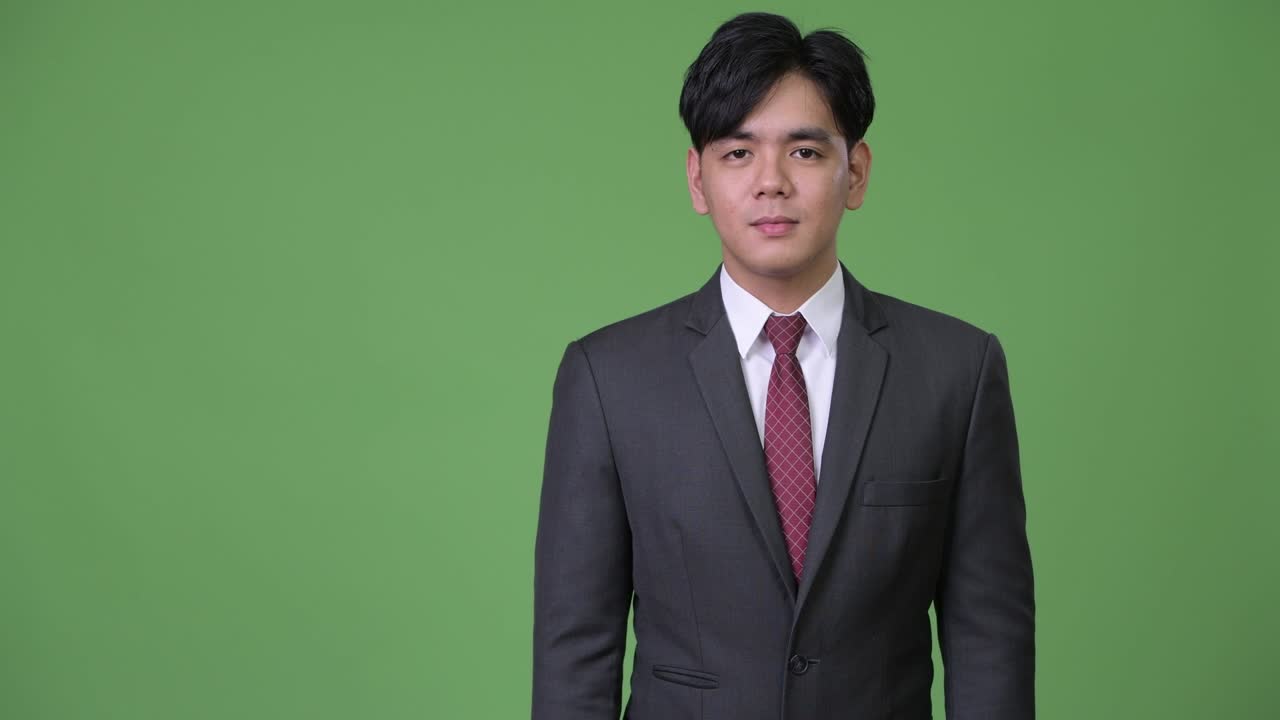무언가를 보여주는 젊은 잘생긴 아시아 사업가
